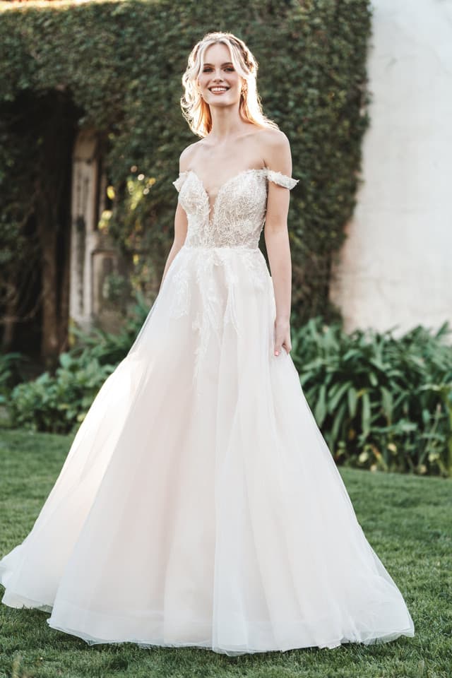 Off-shoulder A-line wedding dress with lace bodice, tulle skirt, and soft romantic silhouette outdoors