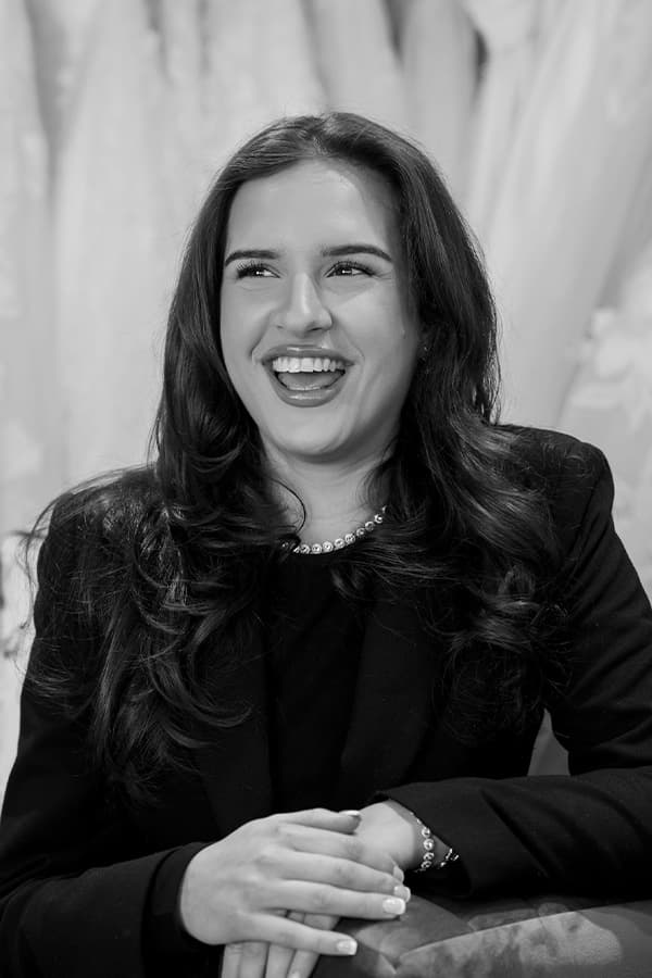 Sophia bridal stylist laughing in boutique with wedding dresses background