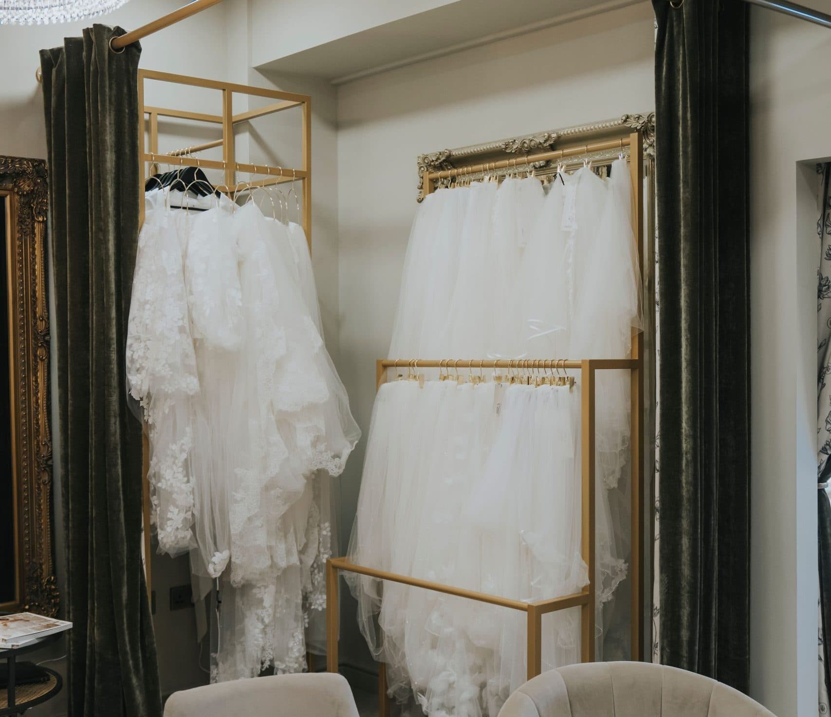 Bridal veils displayed in a luxury wedding boutique with lace veils and soft tulle styles on gold racks